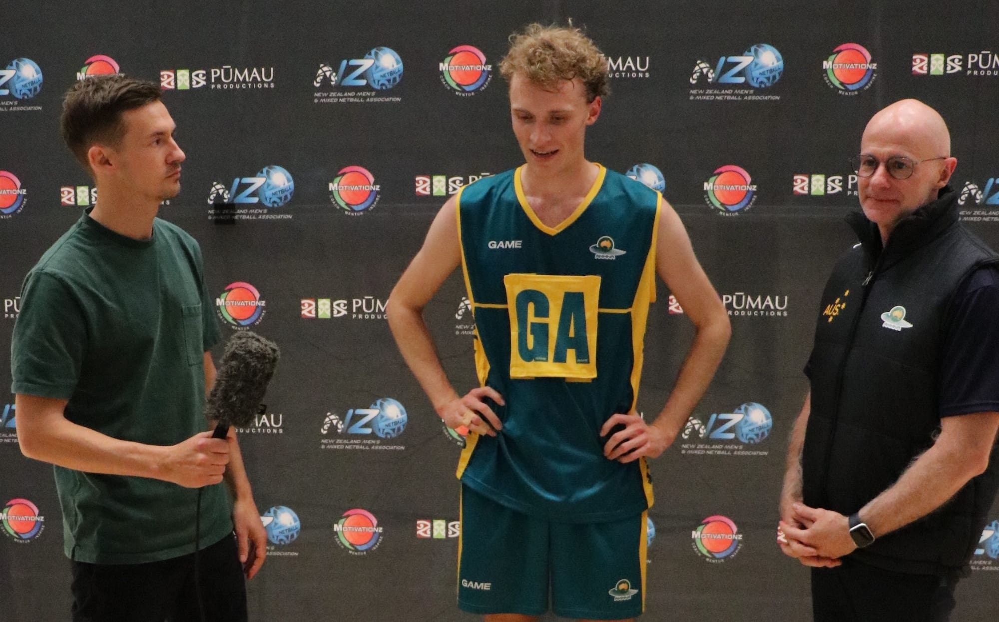 A male Australian netballer is interviewed by Cameron, while another man stands next to them